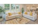 Bright living room with large windows, white sofas with yellow accents, and modern decor at 1112 Prominence Dr, Durham, NC 27712