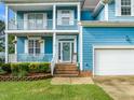 Close-up of the charming blue home's entrance with a welcoming wreath and well-maintained landscaping at 112 Nelson Ln, Clayton, NC 27527