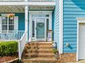 Inviting front entrance with brick steps, a decorative wreath, and a friendly welcome sign at 112 Nelson Ln, Clayton, NC 27527