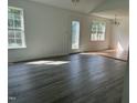 Sunlit living room featuring wood-look flooring and large windows at 118 Hawthorn Dr, Clayton, NC 27520