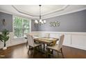 Elegant dining room featuring gray walls, wainscoting, a tray ceiling, and a chandelier at 1212 Sand Pine Dr, Cary, NC 27519