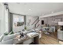 Bright living room with modern decor, hardwood floors, and an open floor plan to the dining area and kitchen at 1238 Coach Station Aly # 101, Raleigh, NC 27601