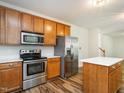 Well-lit kitchen with stainless steel appliances, wooden cabinets, and a bright white countertop island at 1307 Montreux Ct, Mebane, NC 27302