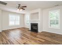 Bright living room with a ceiling fan, fireplace, and natural light from the large windows at 1307 Montreux Ct, Mebane, NC 27302