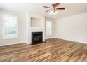 Open living room featuring wood-look floors, a fireplace, and a ceiling fan at 1307 Montreux Ct, Mebane, NC 27302