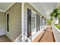 A charming front porch with gray wood-look flooring, gray walls, and white trim and posts at 141 Clay Ridge Way, Holly Springs, NC 27540