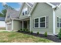View of the side of the home showcasing its manicured landscaping and craftsman details at 1412 Sagamore Dr, Louisburg, NC 27549