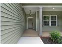 Covered front porch with modern light fixture and well manicured landscaping at 1412 Sagamore Dr, Louisburg, NC 27549