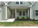 View of the home's entryway with charming landscaping and craftsman style details at 1412 Sagamore Dr, Louisburg, NC 27549