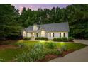 A charming single-Gathering home with lush landscaping and a well-manicured lawn at twilight at 146 Bennett Pl, Clayton, NC 27527