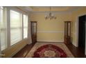 Dining room with wood floors, elegant chandelier, and decorative rug and display cases at 1549 Lily Creek Dr, Cary, NC 27518