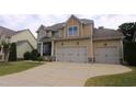 Two-story house featuring a two-car garage, stone accents and a well-maintained lawn at 1549 Lily Creek Dr, Cary, NC 27518