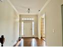 Bright foyer with hardwood floors, white trim, and a transom window above the front door at 1549 Lily Creek Dr, Cary, NC 27518