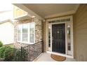 Inviting front entrance featuring a black door, stone facade, and wrought iron railing at 1549 Lily Creek Dr, Cary, NC 27518