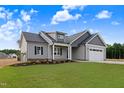 Beautiful new construction home featuring a gray color scheme, well-manicured lawn, and attached two-car garage at 157 Gumtop Dr, Zebulon, NC 27597