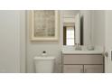 Cozy half bathroom featuring a neutral vanity with a brushed nickel faucet, and a patterned rug on the wall at 1601 Goldfinch Perch Ln, Knightdale, NC 27545