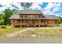 Charming two-story log home with a welcoming covered front porch and beautiful landscaping at 2092 Winwood Farm Rd, Creedmoor, NC 27522