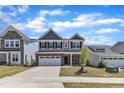 Two-story house with a brick veneer, two-car garage, and lush green lawn at 2100 Curry Meadow Way, Durham, NC 27703