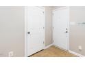 Bright hallway featuring neutral walls, tiled floors, and two white doors at 216 Climbing Ivy Ct, Cary, NC 27511