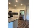 Well-lit kitchen with white cabinets, stainless steel appliances, and granite countertops at 2418 Gathering Square Ct, Fuquay Varina, NC 27526