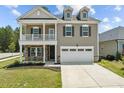 Inviting two-story home with a charming covered porch and attached two-car garage at 2501 Macedonia Pine Dr, Raleigh, NC 27616
