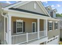 Detailed view of a charming covered front porch with white columns and railings at 2501 Macedonia Pine Dr, Raleigh, NC 27616