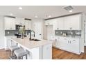 Bright kitchen with white cabinets, stainless steel appliances, and a center island with barstool seating at 2527 Girvan Dr, Fuquay Varina, NC 27526