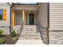 Inviting front porch with stone steps and stained wood columns provide a cozy entryway at 260 Pilot Ridge Rd, Zebulon, NC 27597