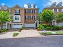 Attractive townhome with brick facade, two-car garage, and well-maintained front yard at 312 Bridgegate Dr, Cary, NC 27519