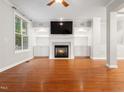 Inviting living room featuring a fireplace, built-in shelves, and hardwood floors at 312 Bridgegate Dr, Cary, NC 27519