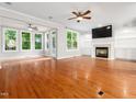 Bright living room with hardwood floors, fireplace, and large windows at 312 Bridgegate Dr, Cary, NC 27519