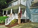 Inviting covered front porch with brick accents, white railings, and a bright red front door at 3300 Neuse Crossing Dr, Raleigh, NC 27616