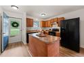 Kitchen with wood cabinets, black appliances, and a center island at 34 Johnston St, Pittsboro, NC 27312
