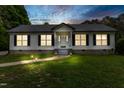 Night view of single-story home with pathway lighting and a well-manicured lawn at 4022 Avents Ferry Rd, Sanford, NC 27330