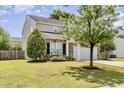 A side view showing a two-story home with manicured shrubs, lawn, and a two-car garage at 430 Dogwood Creek Pl, Fuquay Varina, NC 27526
