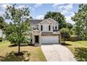 Charming two-story home with stone accents, a well-maintained lawn, and a spacious two-car garage at 430 Dogwood Creek Pl, Fuquay Varina, NC 27526