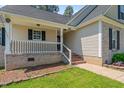 The home features a cozy front porch with brick accents and well-manicured landscaping creating a welcoming entrance at 48 Arlington Dr, Cameron, NC 28326
