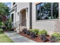 A close-up of a bright brick house with steps, dark windows, and landscaping at 4921 Sweetbriar Dr, Raleigh, NC 27609
