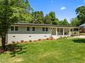 Charming home featuring a well-maintained lawn, brick facade, covered entryway, and a convenient carport at 5208 Melbourne Rd, Raleigh, NC 27606