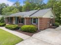 Brick home with decorative ironwork, covered porch, and meticulous landscaping at 5529 Shadowbrook Dr, Raleigh, NC 27612