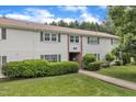 Inviting townhouse featuring lush landscaping, vinyl siding and green shutters at 5602 Falls Of Neuse Rd # E, Raleigh, NC 27609