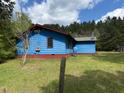 Exterior side view of a blue home with green lawn, and red trim at 5644B Old Roxboro Rd, Oxford, NC 27565