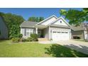 Single-Gathering home boasts beautiful landscaping, a two-car garage, and a well-manicured lawn at 65 Wood Green Dr, Wendell, NC 27591