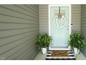 Charming front door with a decorative wreath, plants, and a 'Sweet Home' welcome mat at 65 Wood Green Dr, Wendell, NC 27591