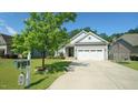 This home features a well-kept front yard, two-car garage, and inviting curb appeal at 65 Wood Green Dr, Wendell, NC 27591