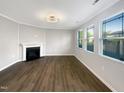 Bright living room featuring a fireplace, hardwood floors and large windows at 664 Lavenham Ln, Fuquay Varina, NC 27526