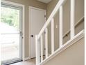 Bright entryway with stairs, features a door with glass and white railings, enhancing the home's appeal at 7408 Sandy Creek Dr, Raleigh, NC 27615