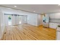 Open living area featuring a modern kitchen, stainless appliances, and hardwood floors at 9614 Quail Roost Rd, Bahama, NC 27503