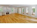 Bright living area featuring hardwood floors, white walls, and large windows offering scenic views at 9614 Quail Roost Rd, Bahama, NC 27503