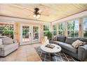 Bright sun room featuring wood paneled walls, a ceiling fan, neutral furniture, and a tile floor at 100 Mill Creek Dr, Fuquay Varina, NC 27526